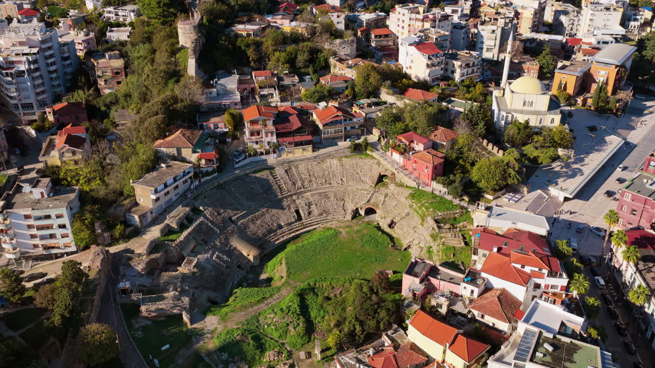 Aerial drone view of one of the Balkans' largest ancient amphitheatres, partially excavated and surrounded closely by local houses in Durres, Albania