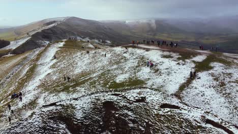 Aerial-view-Mam-Tor,-Peak-District-mountain-panning-shot-of-people-at-summit