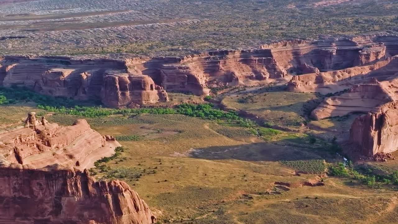 Kanyonlar, çöl bitkileri ve jeolojik oluşumlar içeren Mojave manzarası