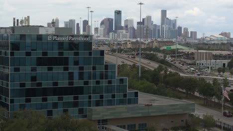 drone view of planned parent hood building and downtown houston, texas