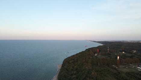 parapente sobre la costa del mar báltico en una tranquila noche azul pastel, vista aérea