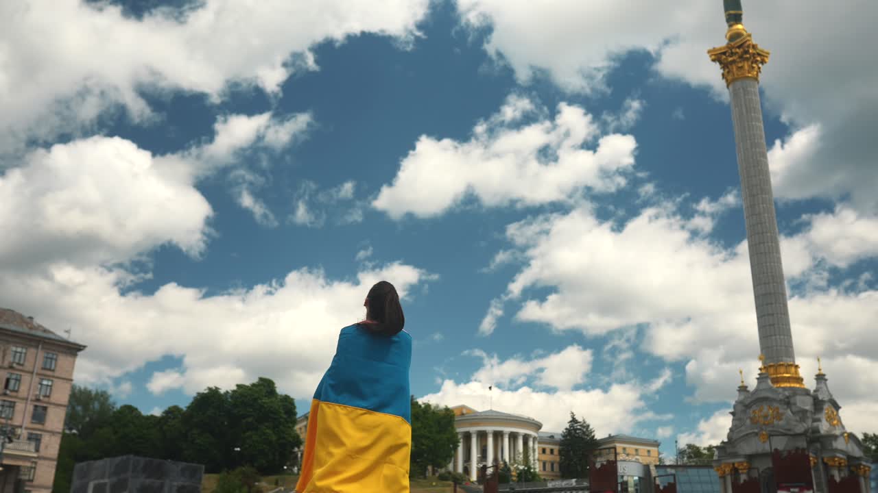 mujer sosteniendo una bandera ucraniana en una plaza de la ciudad