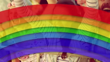 icono del arco iris contra un grupo de personas bailando juntos en un concierto
