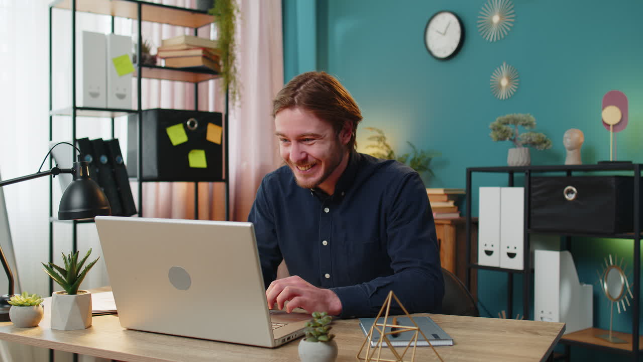 노트북에서 일하는 사업가 갑작스러운 승리에 충격을 받았습니다.