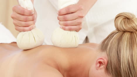 woman enjoying a herbal compress massage