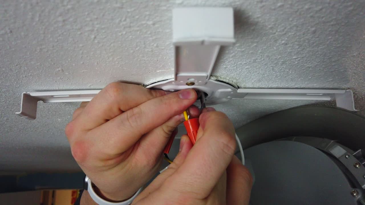 Twisting a few wire nuts together connecting the wires of a new LED light install