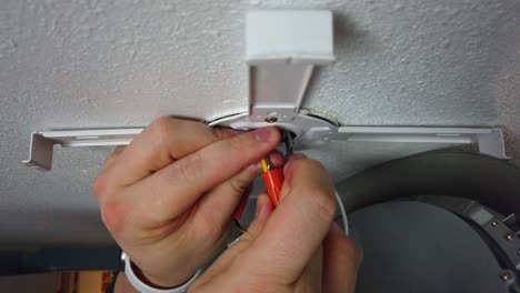 retorciendo algunas tuercas de alambre juntas conectando los cables de una nueva instalación de luz led