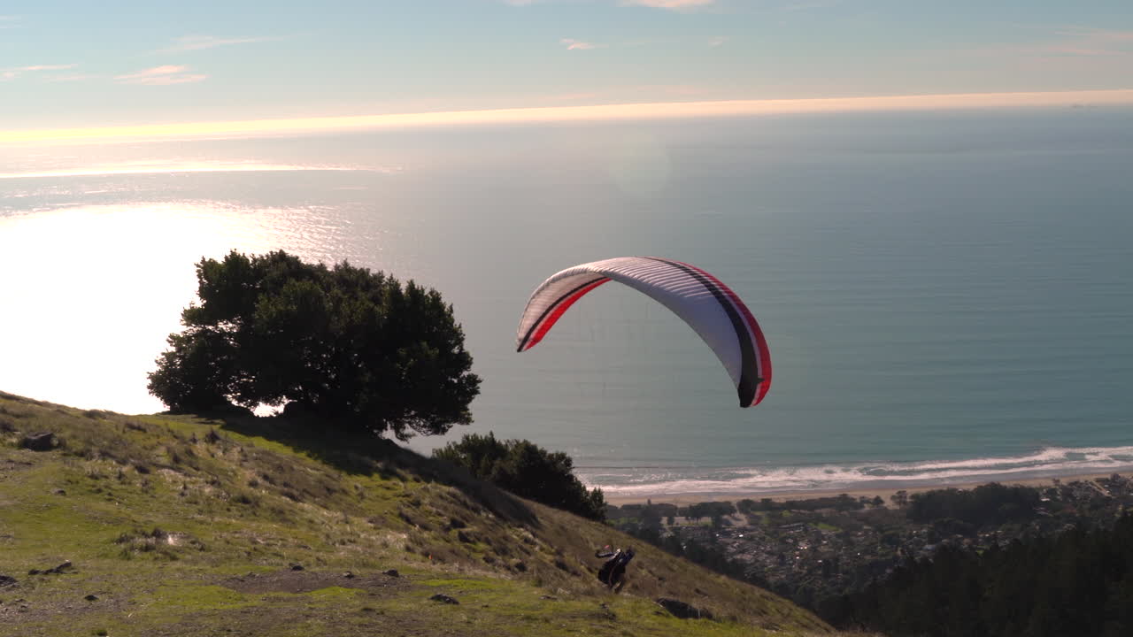 Hombre haciendo parapente en el Monte Tamalpais y la playa Stinson en California