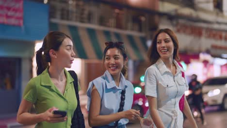 three friends enjoying a night out in a city street