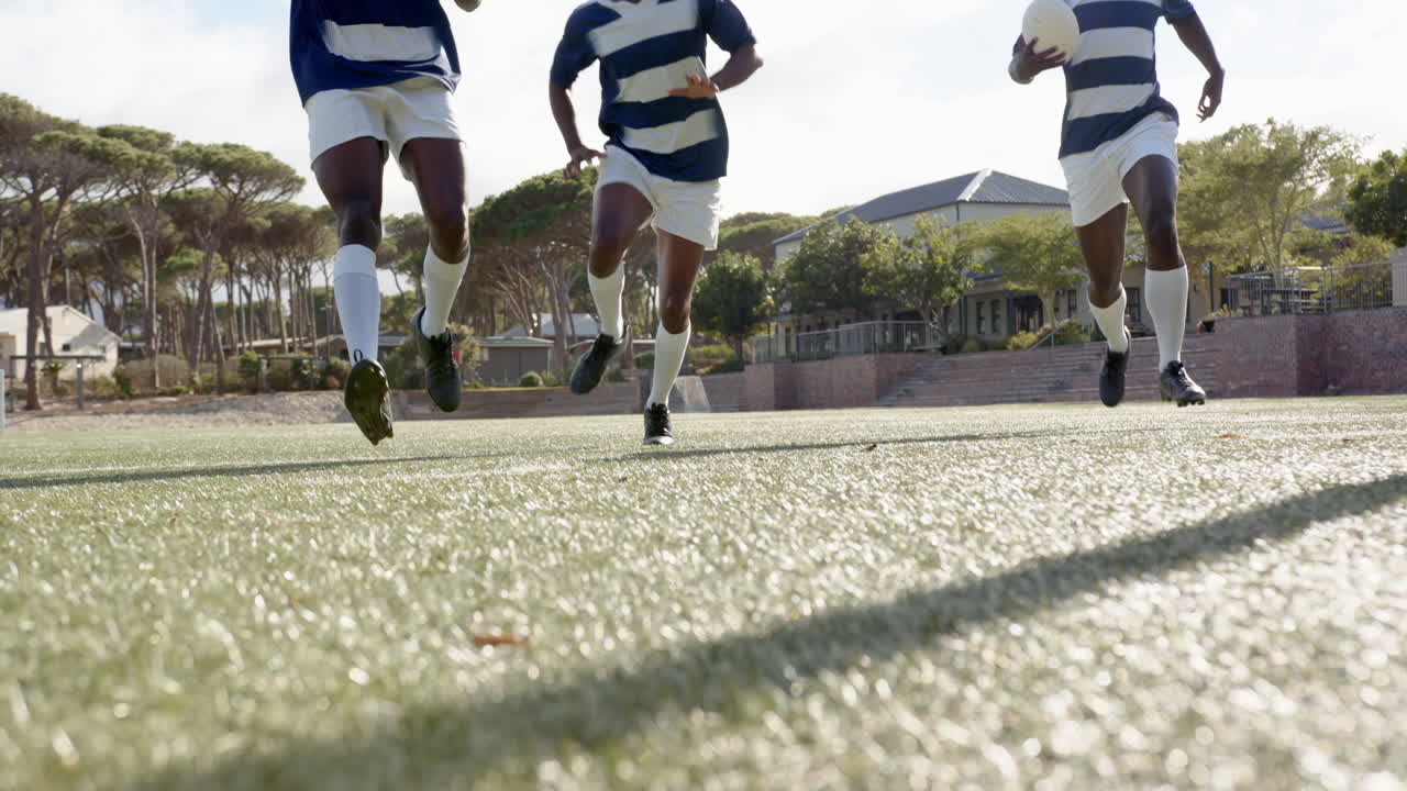 Playing soccer, african american men running on field and kicking ball during game, copy space
