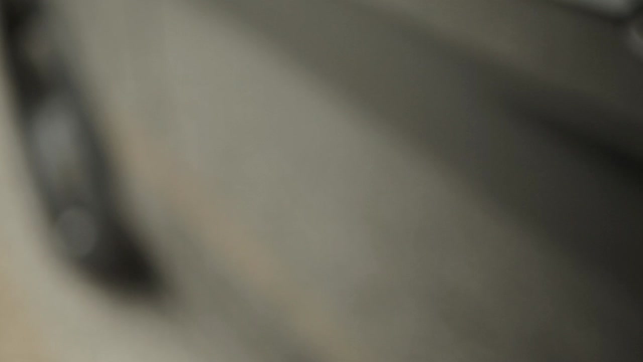 Close-up shot of a car's door handle in motion, showcasing a sleek, modern design with a subtle reflection