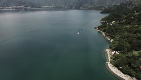 Atitlan-see-In-Guatemala-Und-Boot,-Das-Entlang-Der-Küste-Navigiert