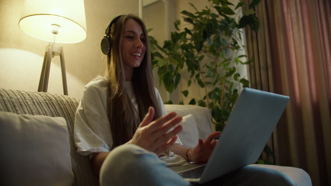 mujer sonriente con auriculares realiza llamadas de conferencia en computadora portátil, habla con un profesor en línea, estudia, trabaja desde casa
