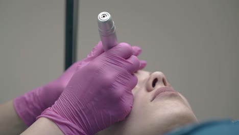 specialist-hands-in-pink-sterile-gloves-with-tattoo-gun