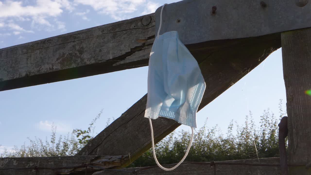 Face mask left on wooden gate medium shot