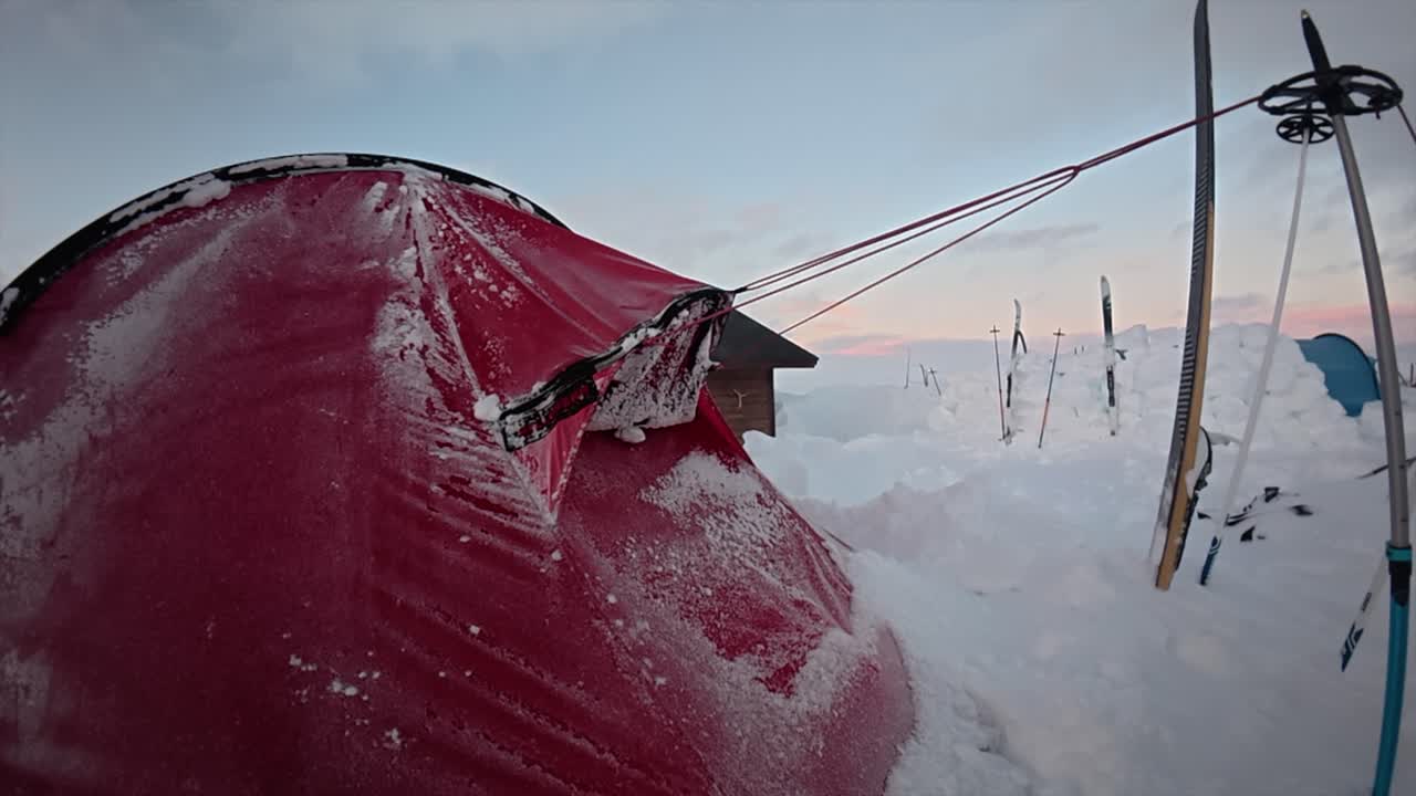 Steam emits from frosty red tent in northern winter camp snow scene