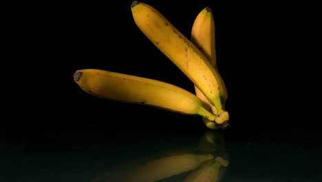 bananas falling on black background