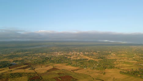 vue aérienne d'une ville et de champs ensoleillés, heure d'or en afrique rurale - suivi, tir de drone