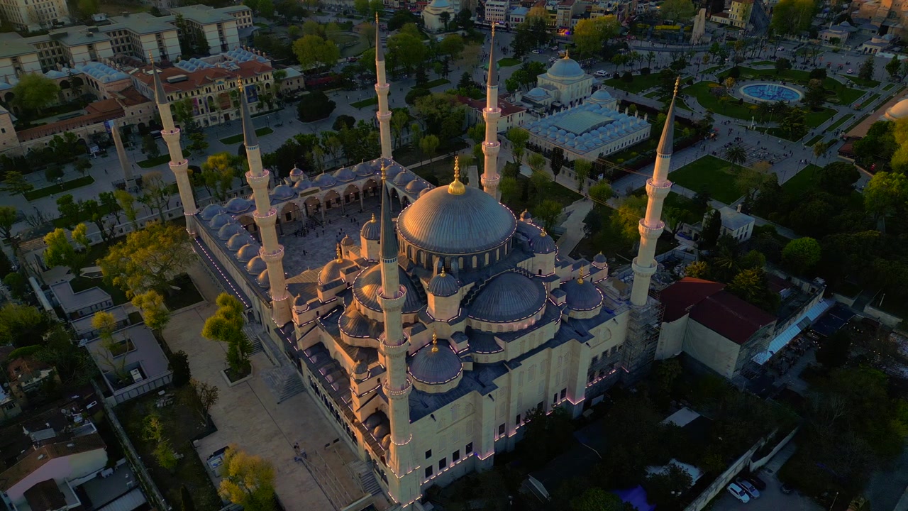 Moschea di Sultan Ahmed con i suoi minareti e le sue cupole bagnate da una luce dorata sullo sfondo dello skyline di Istanbul e del Bosforo. Splendida vista aerea con drone che punta verso il basso