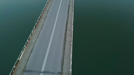 파란색 시간 동안 그리스 호수에서 다리 위로 전방 드론 샷의 수직 패닝