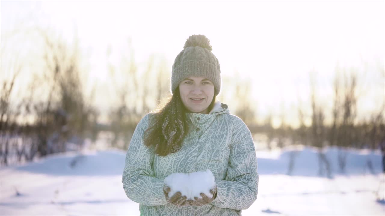 Woman playing with snow in winter