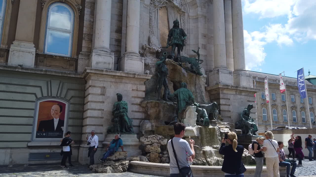 4K Statue and fountain that represents people hunting a big deer. A crowd of people are looking at the fountain. Footage from right to left in a stabilised motion.