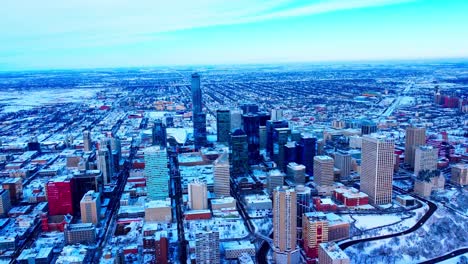 winter aerial flyover downtown edmonton overlooking the buildings from southside to the north west side snow covered skyscrapers and the skyline with the old airport in the horizon cleared out3-3