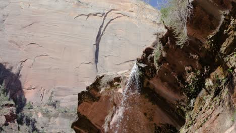 Toma-En-Cámara-Ultra-Lenta-De-Agua-Cayendo-De-La-Roca-En-El-Sendero-De-La-Piscina-Esmeralda-En-El-Parque-Nacional-Zion,-Utah