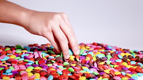 hands sorting colorful candies on a table