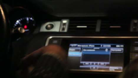 person adjusting car infotainment system