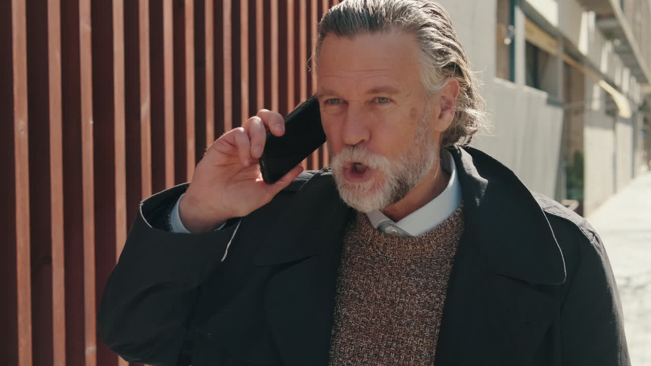 Stilig mann smiler mens han snakker i telefonen