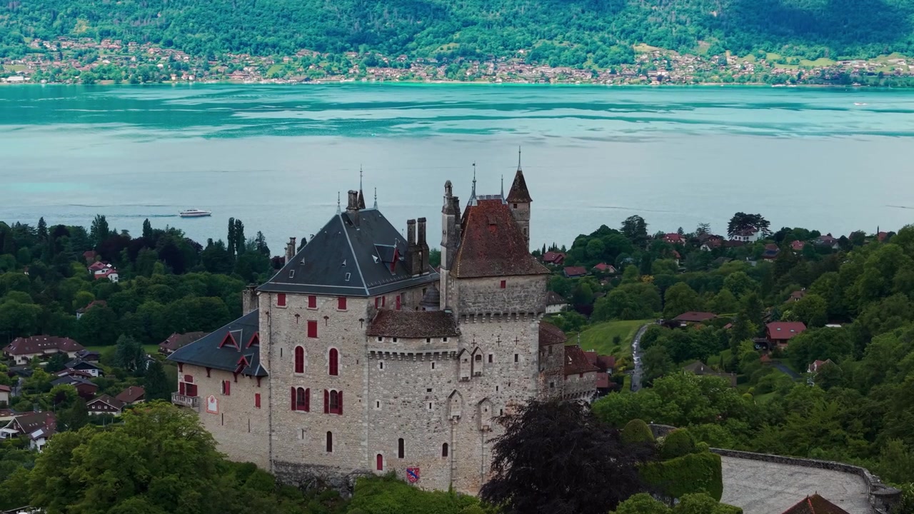 Ripresa aerea ravvicinata del Castello di Menthon-Saint-Bernard in una giornata di sole, che rivela il Lago di Annecy sullo sfondo, dipartimento dell'Alta Savoia, regione dell'Alvernia-Rodano-Alpi, Francia
