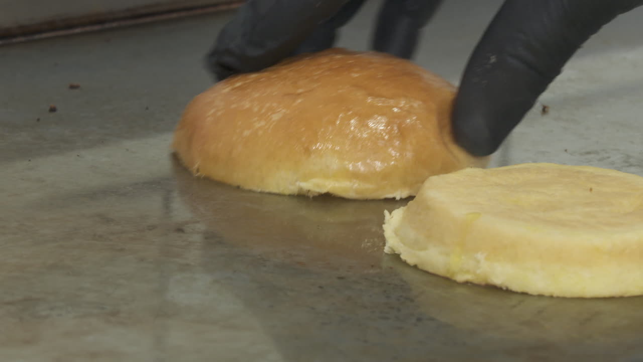Preparing burger buns on a hot plate