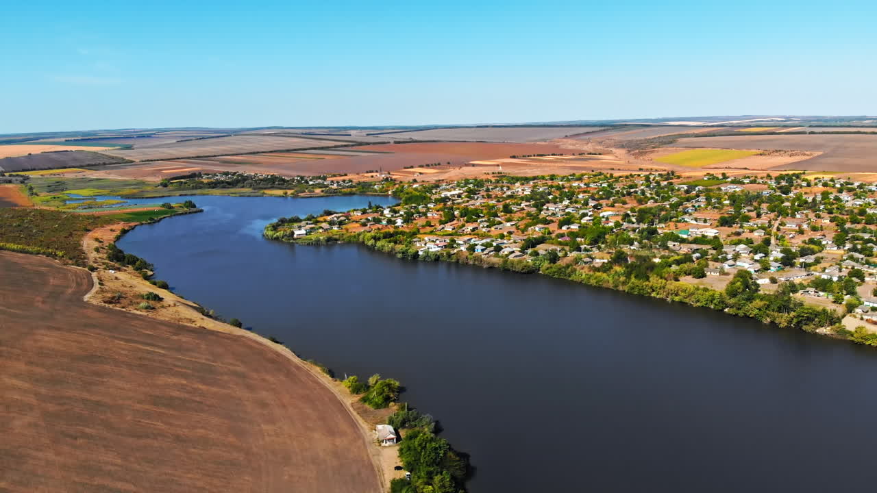 Maramonovca village located on the coast of a lake. Aerial drone view with fields on the background in Moldova