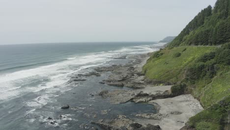 Slow-dropping-pan-of-rocky-Oregon-coastline-waves-and-rocky-cliffs