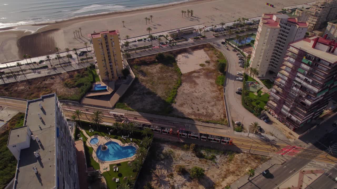 Tram che attraversa i binari sulla costa di San Juan de Alicante all'alba