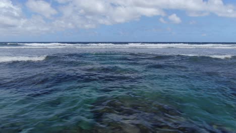 ocean waves rolling over a tropical reef in maui