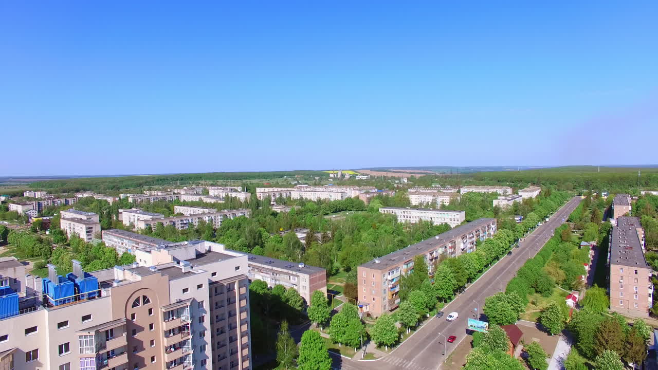 Quarters with multiple blocks of flats in the residential area. Long road and crossroads along green streets.
