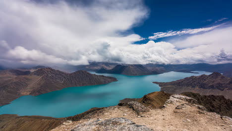 panoramic view of a turquoise mountain lake under a dramatic cloudy sky