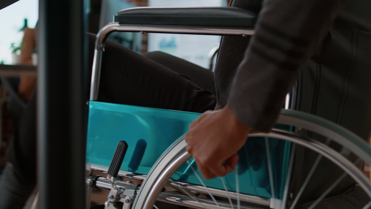 Joven empleado entrando en una oficina de negocios en silla de ruedas
