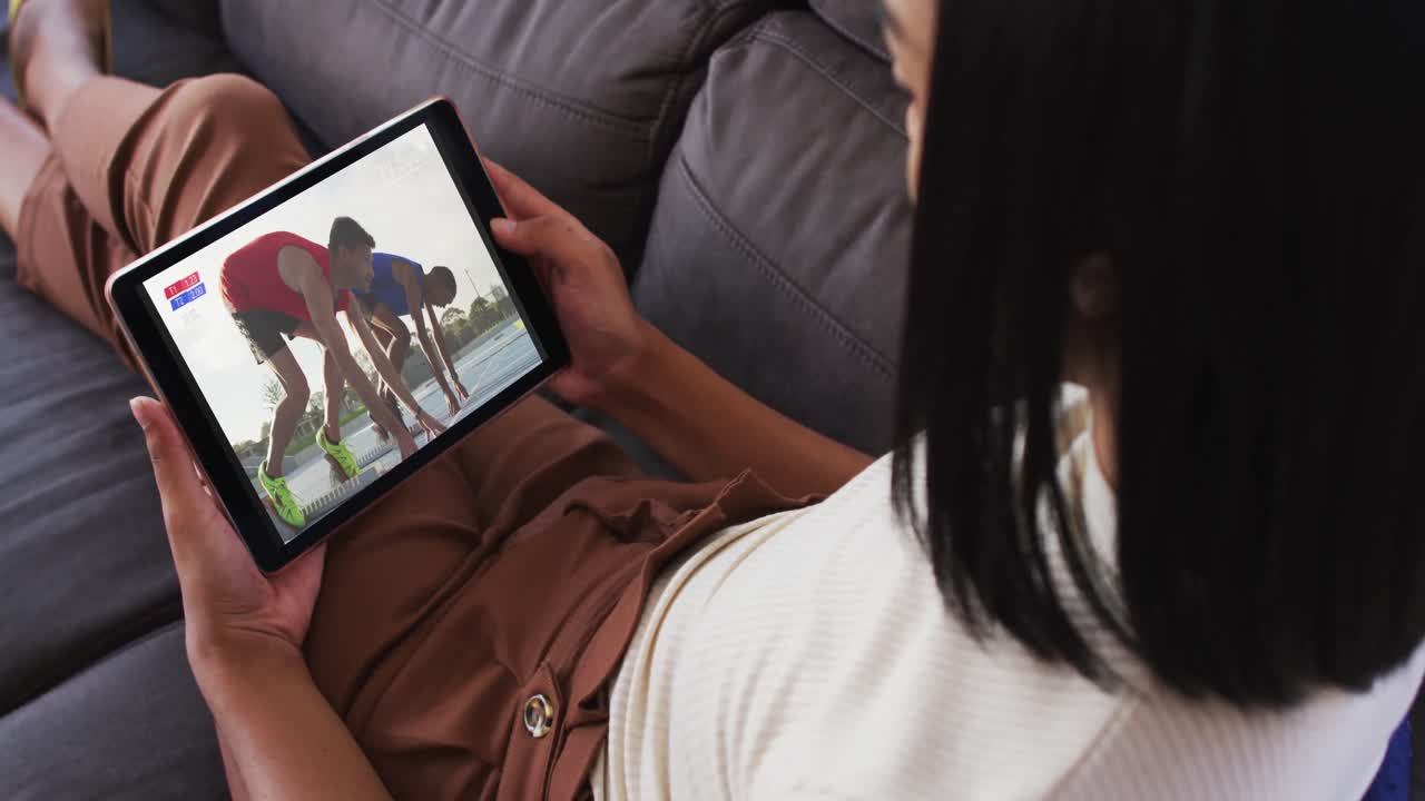 Composite of woman sitting at home on couch watching athletics running event on tablet