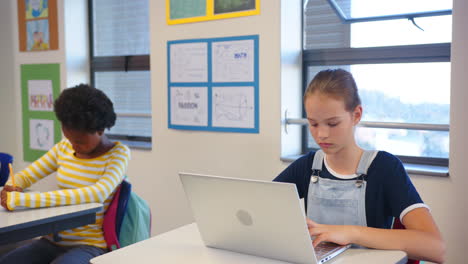 in school, girl using laptop and scratching head, sitting at desk in classroom