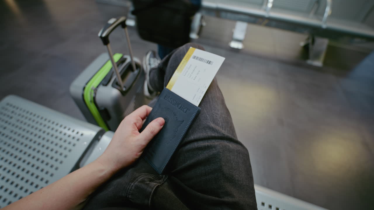Passenger waiting at the airport with passport and boarding pass