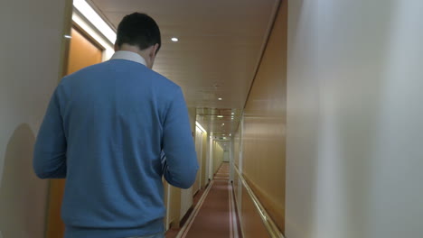 adult man walking along a corridor of ocean cruise ship