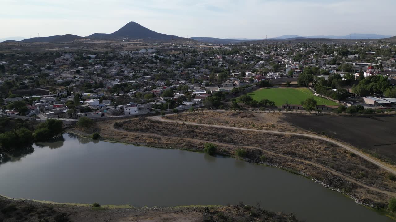 Urban area with a lake, next to a rural zone and a housing development. Drone shot showing the contrast.
