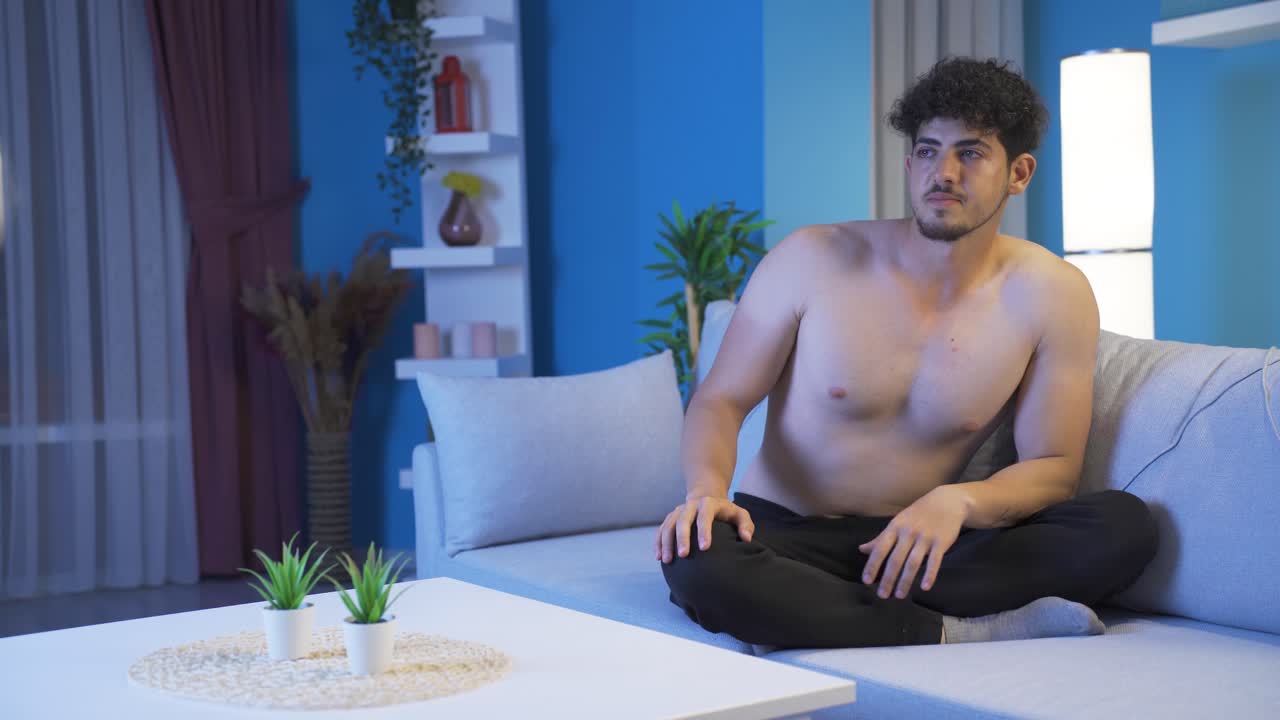 젊은 남자는 밤에 집에서 지루하고 우울합니다.