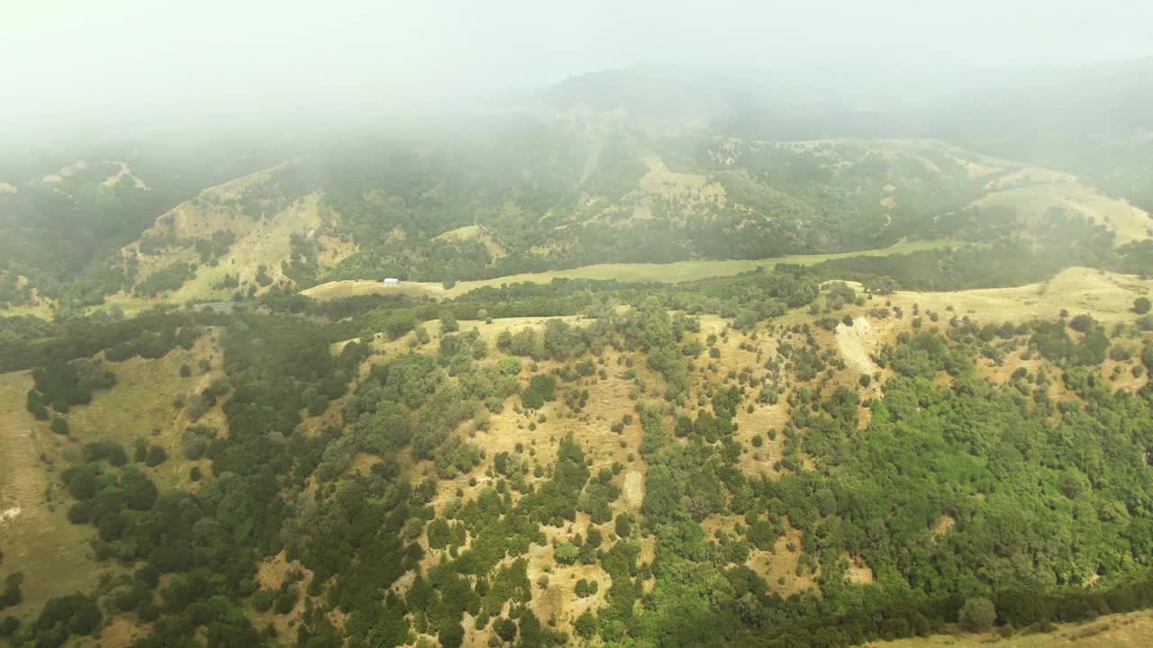 vista de drones de niebla espesa rodando sobre colinas montañosas y valles en el campo de nueva zelanda