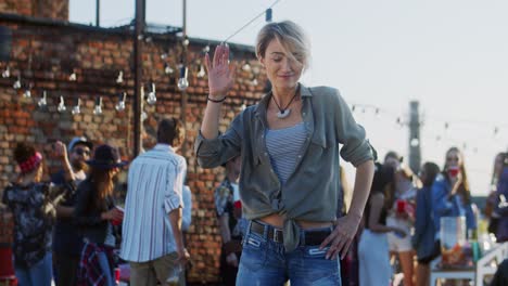 Joven-Mujer-Elegante-Y-Atractiva-Con-El-Pelo-Rubio-Corto-Bailando-Frente-A-La-Cámara-En-La-Fiesta-De-La-Azotea