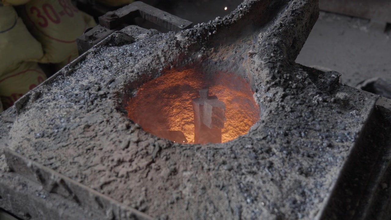 Una vista ravvicinata mostra del metallo solido circondato da calore arancione all'interno della camera circolare di un forno fusorio