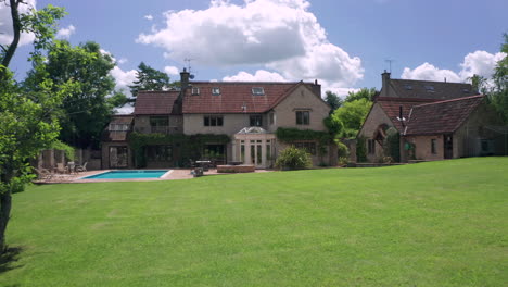 dolly zoom into a countryside home through trees in the garden